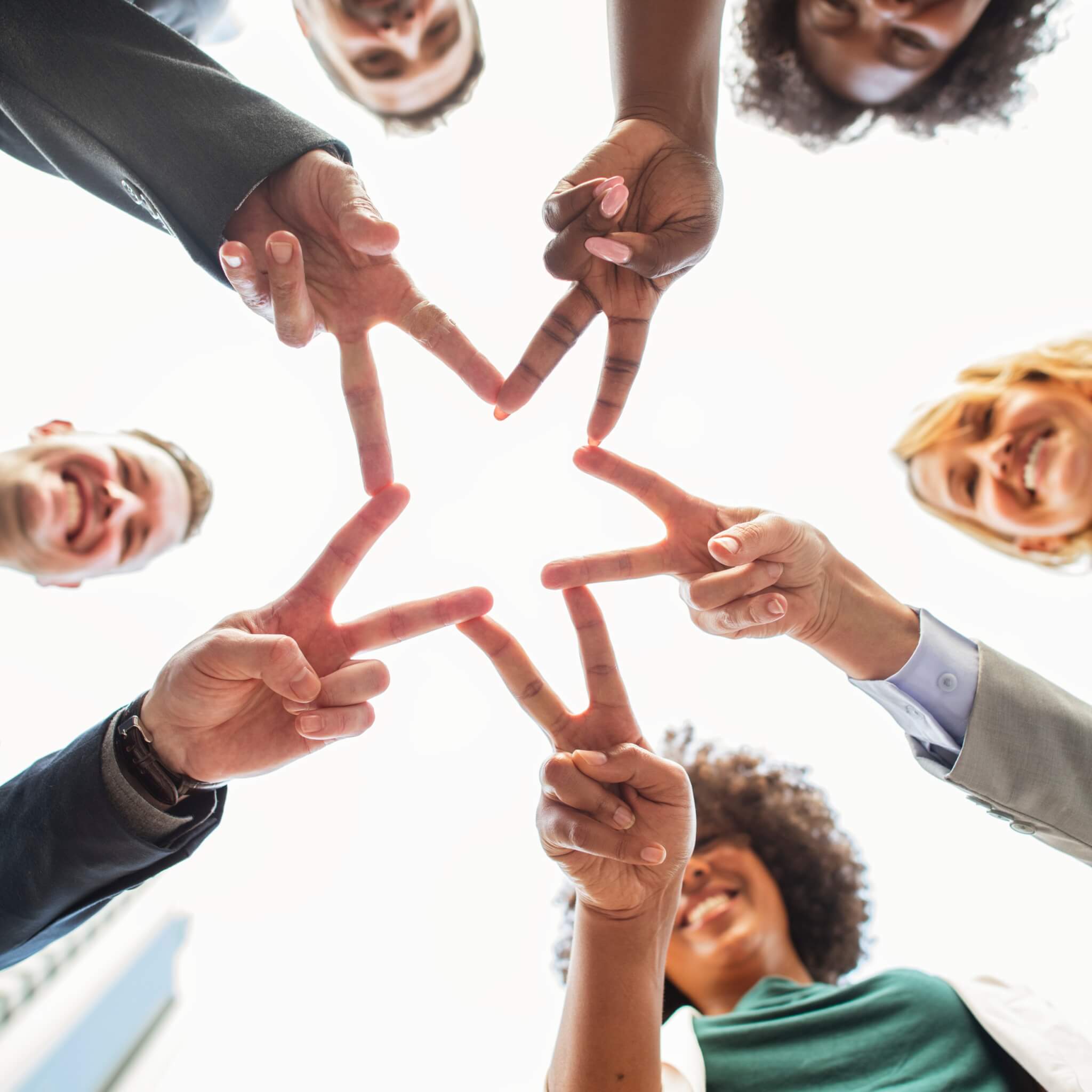 A few people forming a sign by joining their hands